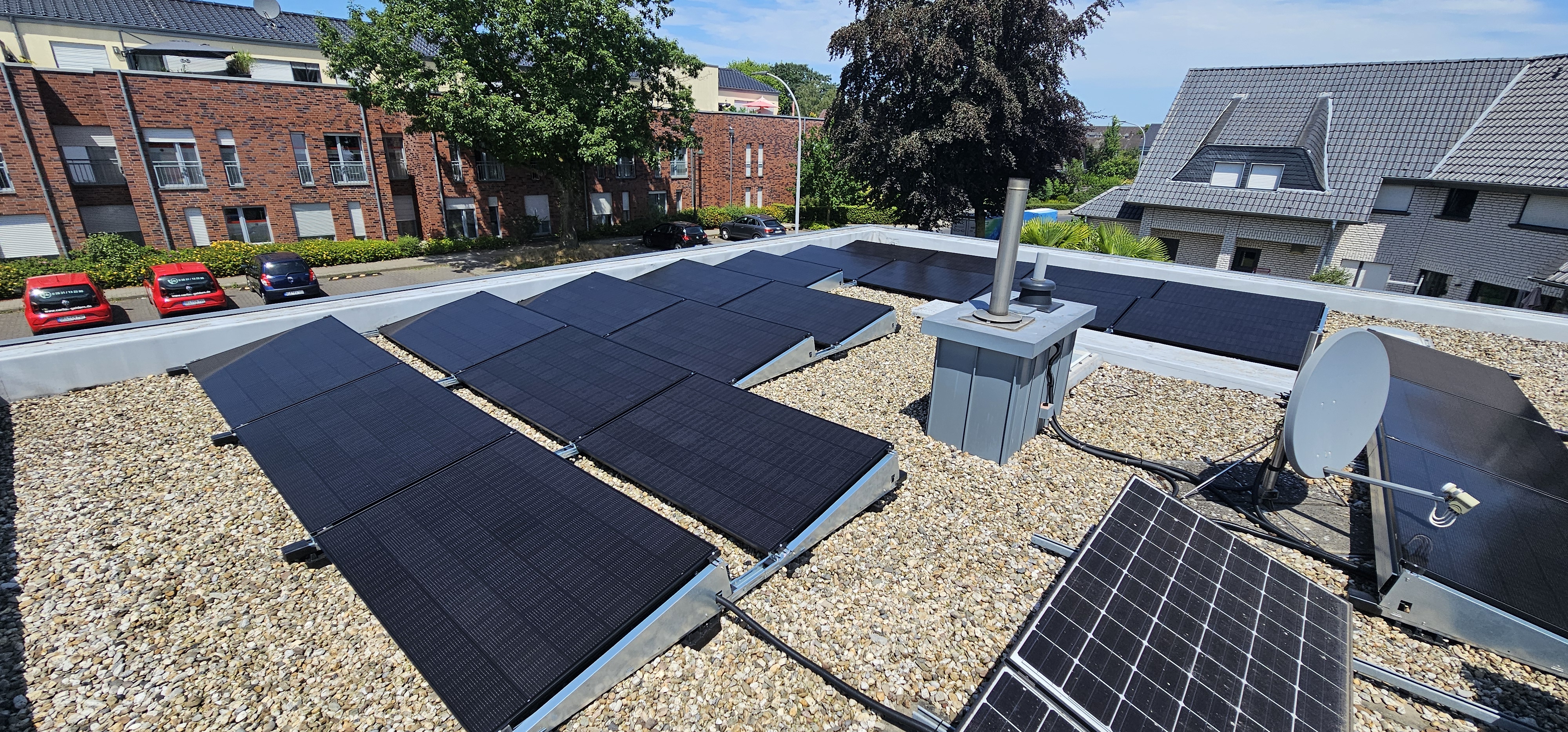 Fertige Flachdach-PV-Anlage vor Backsteingebäude